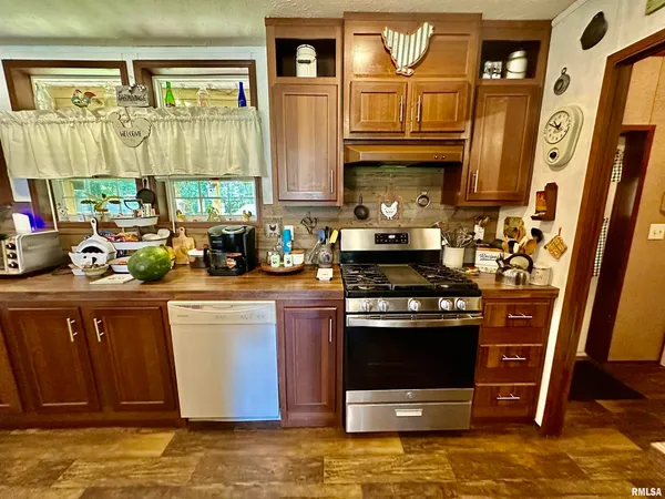 a kitchen with stainless steel appliances granite countertop a stove a sink and a microwave