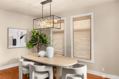 a dining room with furniture potted plants and wooden floor