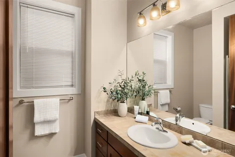 a bathroom with a granite countertop sink and a mirror