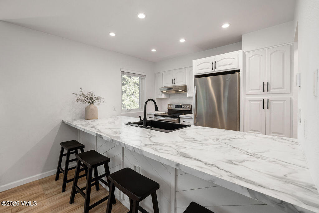 570 Homestead Drive, Unit 41 Edwards, CO 81632 - Photo 6 of 28 a kitchen with kitchen island a appliances dining table and chairs