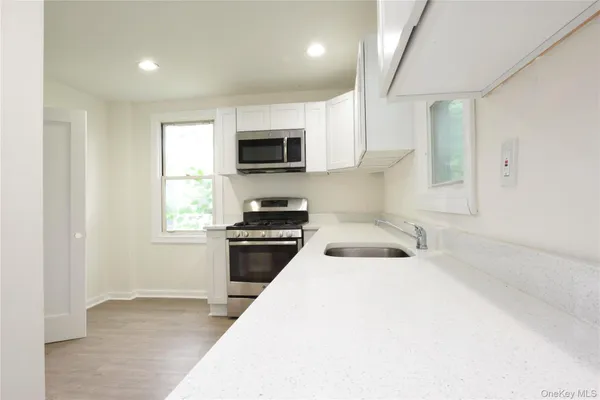 a kitchen with a sink a microwave and cabinets