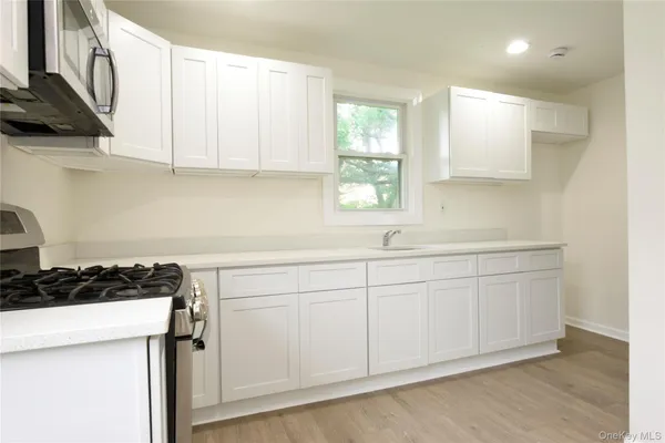 a kitchen with white cabinets and a stove