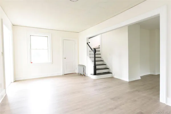 an empty room with a staircase and a white door
