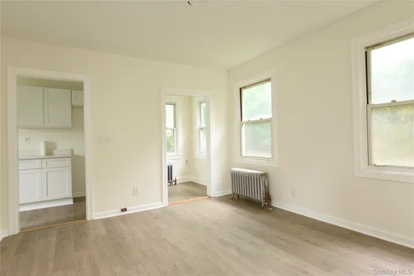 an empty room with windows and cabinet