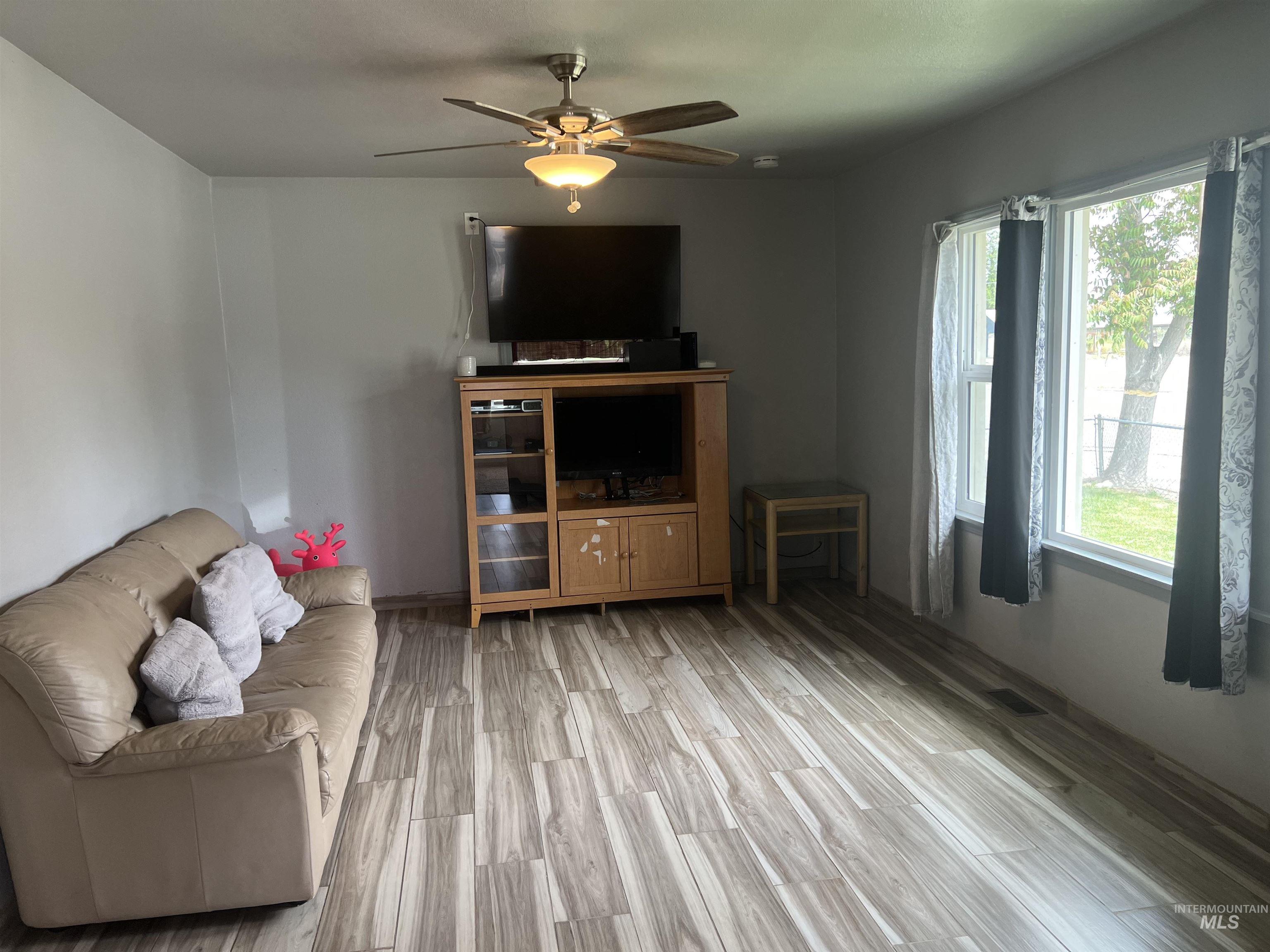 121 North 1st Street Nyssa, OR 97913 - Photo 11 of 20 Interior space featuring wood-finish flooring, light grey walls, and a ceiling fan with integrated lighting