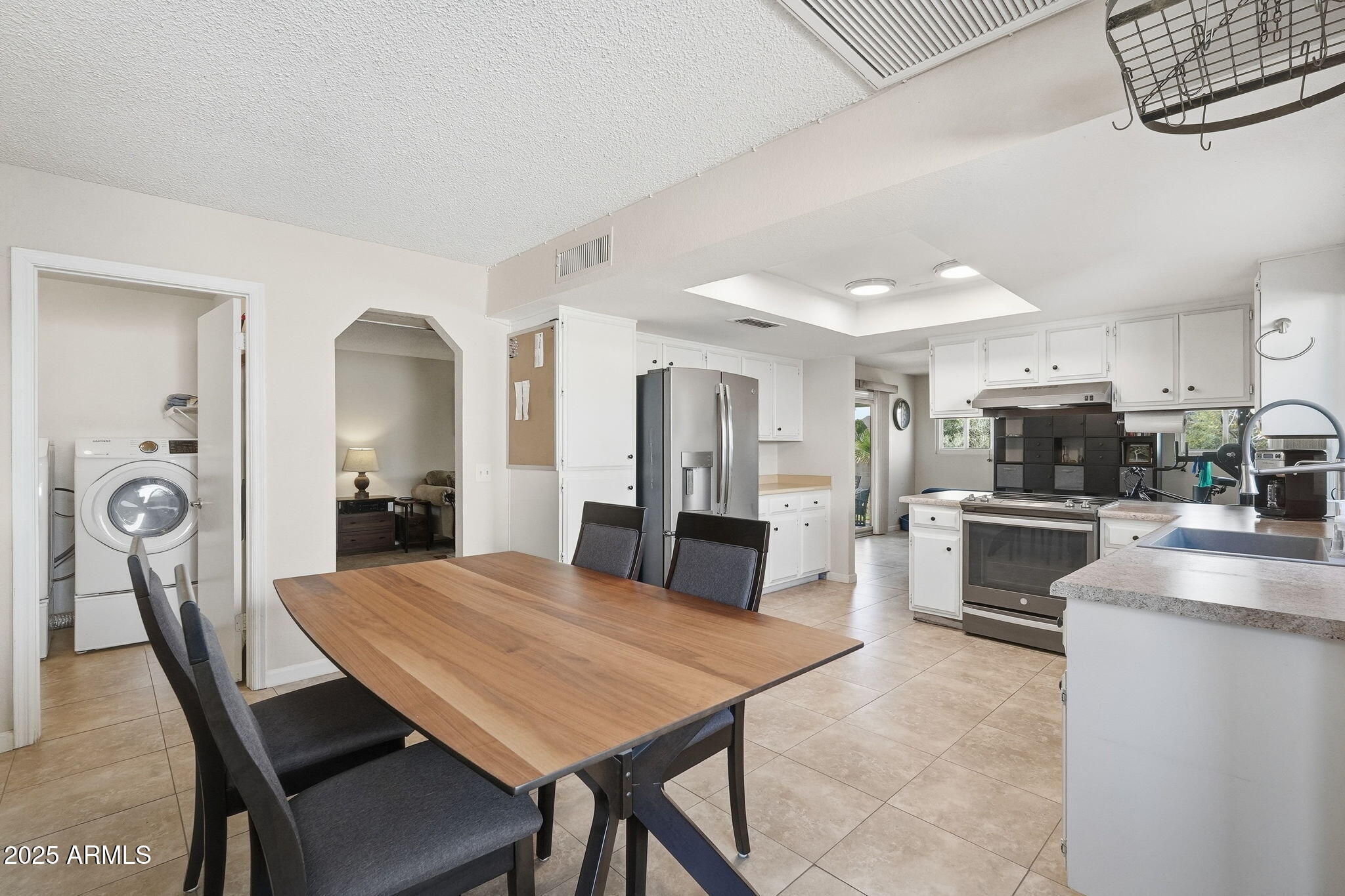 1504 North Iowa Street Chandler, AZ 85225 - Photo 14 of 34 a kitchen with stainless steel appliances refrigerator dining table and chairs