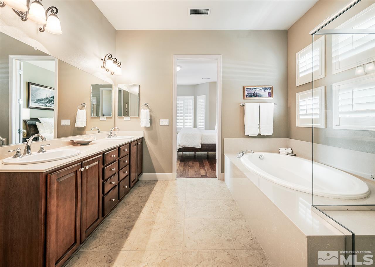 9360 Chalkstone Way Reno, NV 89523 - Photo 17 of 26 a spacious bathroom with a double vanity sink a tub a mirror and a double vanity sink