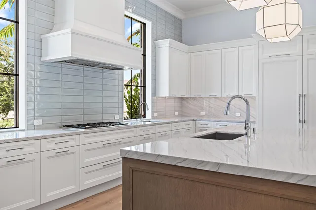 a kitchen with granite countertop white cabinets and a sink