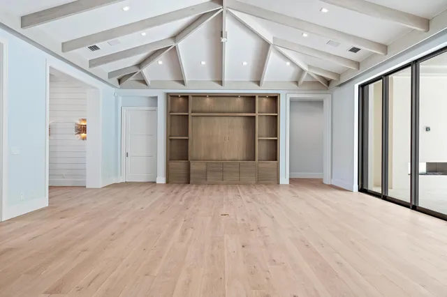 an empty room with wooden floor and door