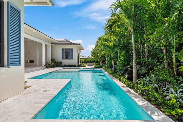 a front view of a house with a yard and potted plants