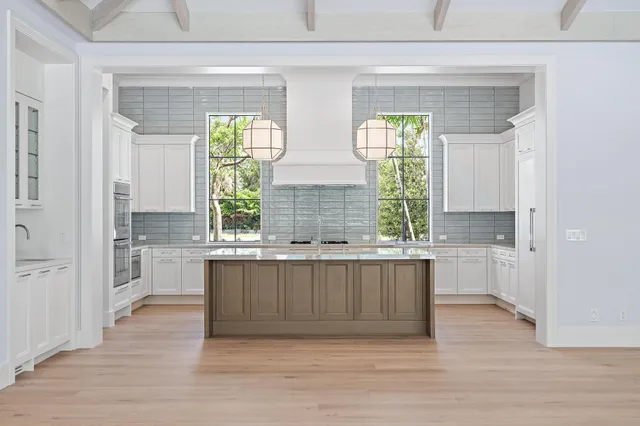 a kitchen with stainless steel appliances granite countertop a stove a sink and a wooden floors