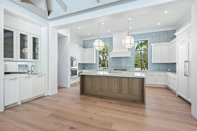 a large kitchen with kitchen island a sink stainless steel appliances and cabinets
