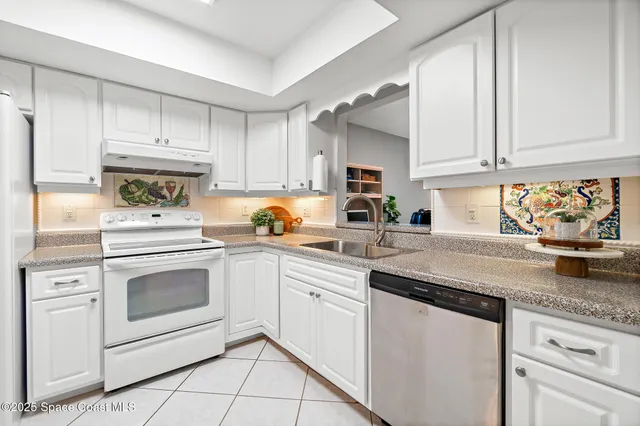 a view of a patio with table and chairs potted plants and large tree