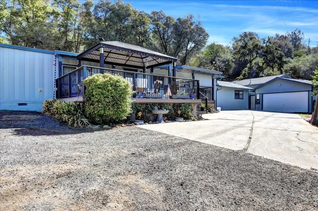 a front view of a house with a yard and trees
