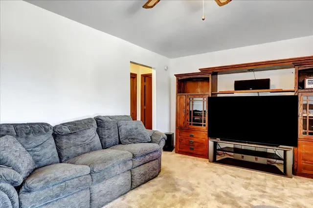 a living room with furniture and a ceiling fan