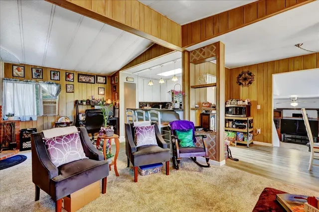 a living room with furniture a wooden floor and next to a window