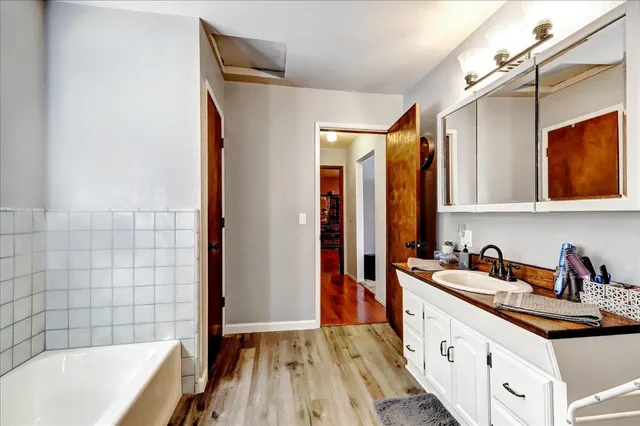 a view of a hallway with wooden floor and door