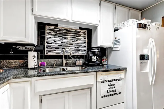 a kitchen with stainless steel appliances granite countertop a sink and cabinets