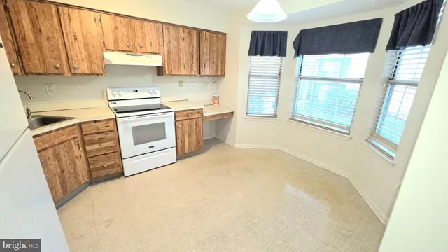 a kitchen with a refrigerator a stove a sink and a window