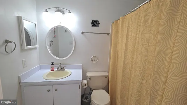 a bathroom with a sink vanity mirror and toilet