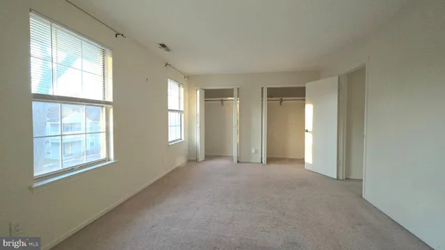 an empty room with windows and closet