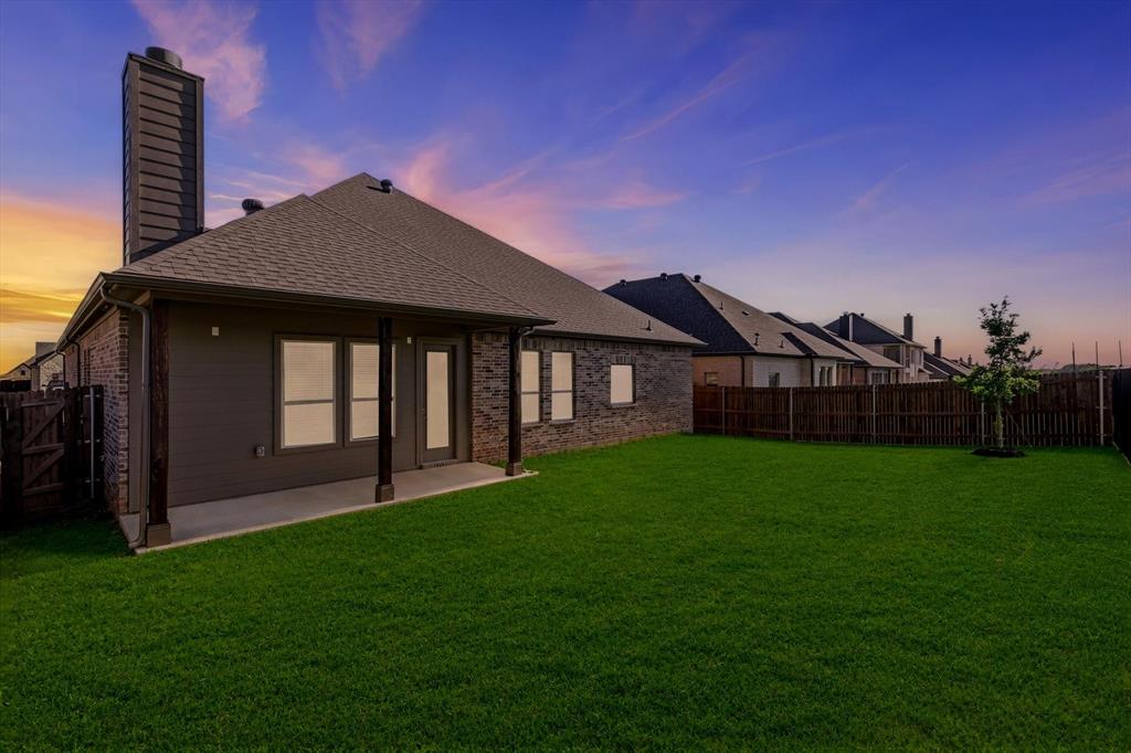 4017 Eagles Bluff Road Midlothian, TX 76065 - Photo 3 of 38 Expansive backyard featuring a manicured lawn, a covered patio, and a privacy fence