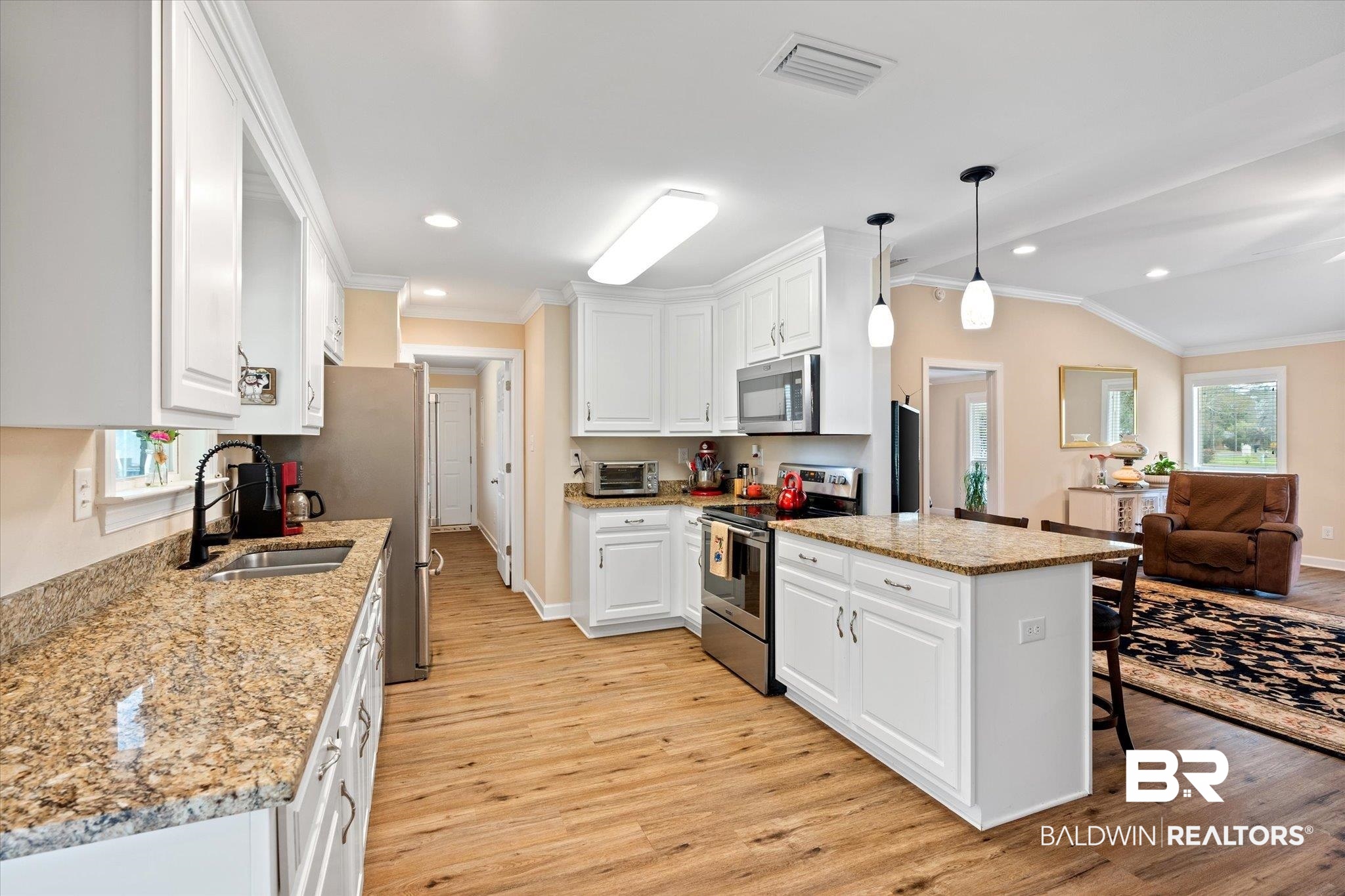 734 West Section Avenue Foley, AL 36535 - Photo 10 of 50 Kitchen featuring visible vents, a sink, white cabinetry, stainless steel appliances, and crown molding