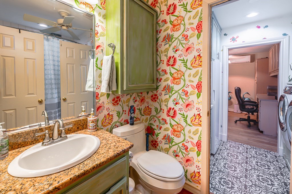 9 Sandra Drive Fulton, TX 78382 - Photo 15 of 35 a bathroom with a granite countertop toilet a sink a mirror a shower curtain and a bath tub