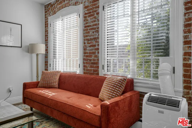 a kitchen with stainless steel appliances granite countertop a dining table chairs refrigerator and sink