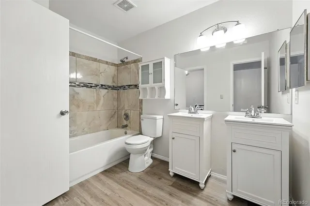 a bathroom with a toilet a sink a mirror a bathtub and shower