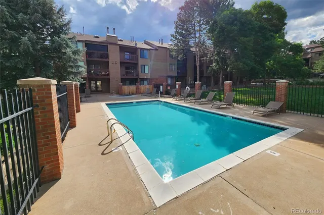 a view of a swimming pool with a patio and a yard