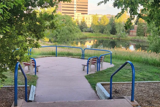 a view of a lake with a bench and trees around