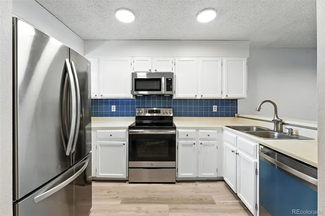 a kitchen with stainless steel appliances a refrigerator stove and sink