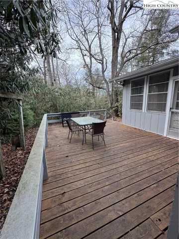 a view of a roof deck with table and chairs and wooden floor