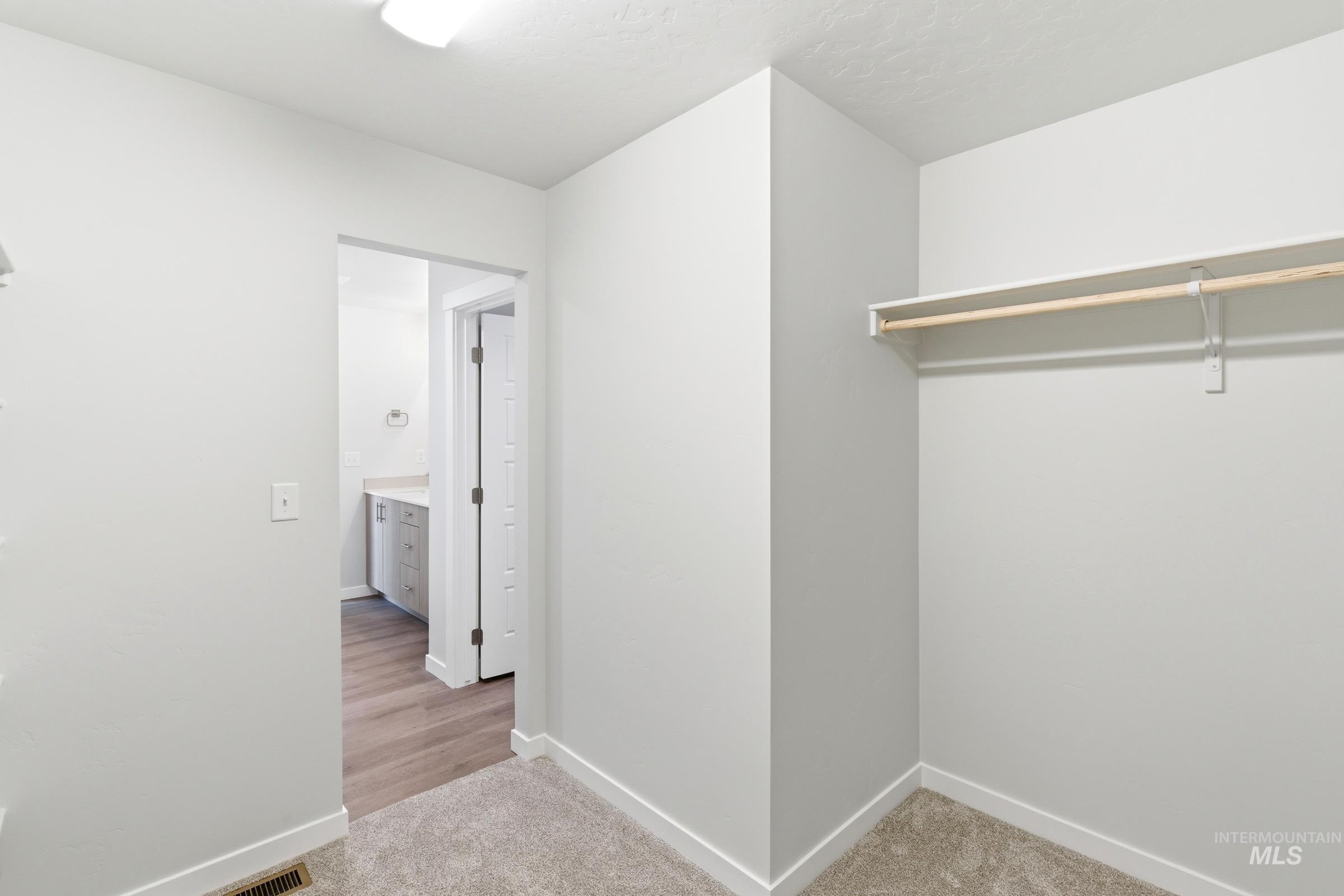 12829 Decatur Street Nampa, ID 83651 - Photo 30 of 33 Walk-in closet featuring light gray carpeting, white walls, and a built-in hanging rod with shelving