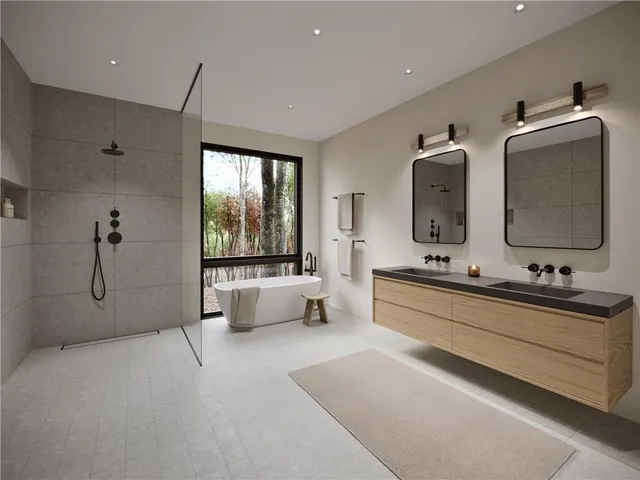 a bathroom with double vanity sink a two mirror a bathtub and next to a window