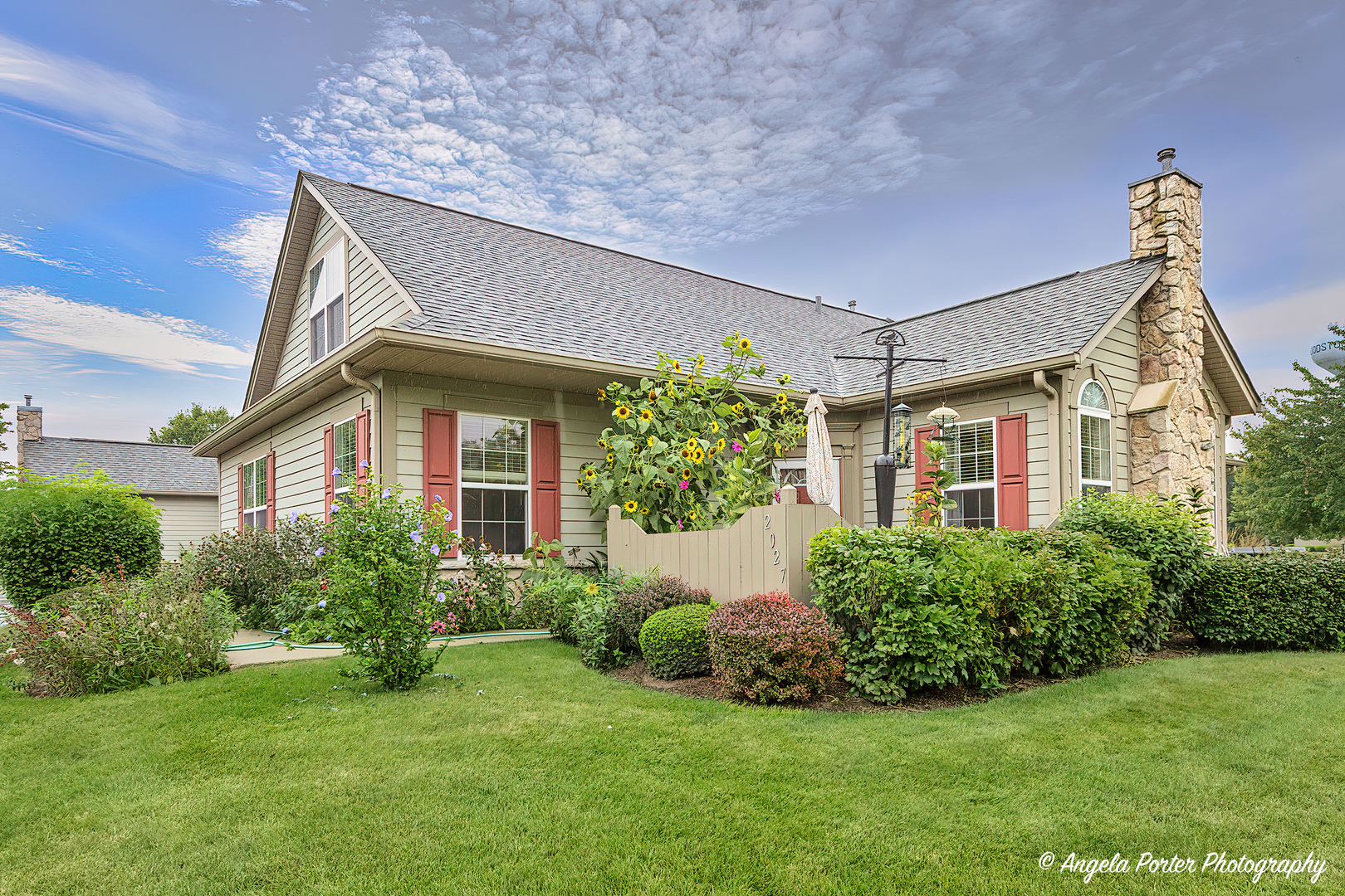 2027 Olmstead Drive, Unit 2027 Woodstock, IL 60098 - Photo 1 of 1 a view of a house with a yard and plants