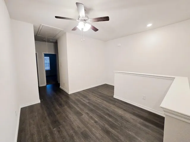 a view of an empty room with wooden floor