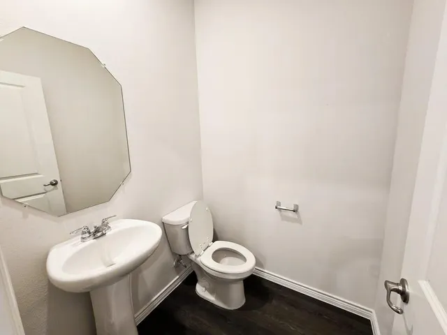a bathroom with a toilet sink and mirror