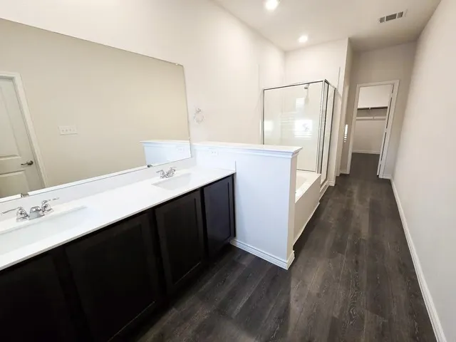 a bathroom with a double vanity sink and mirror