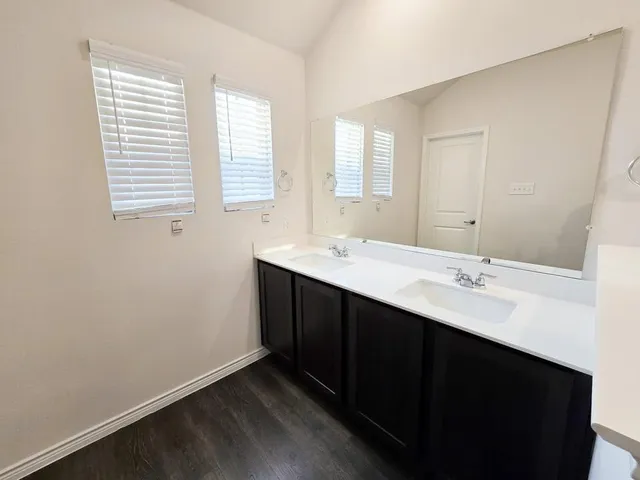a bathroom with a double vanity sink and mirror