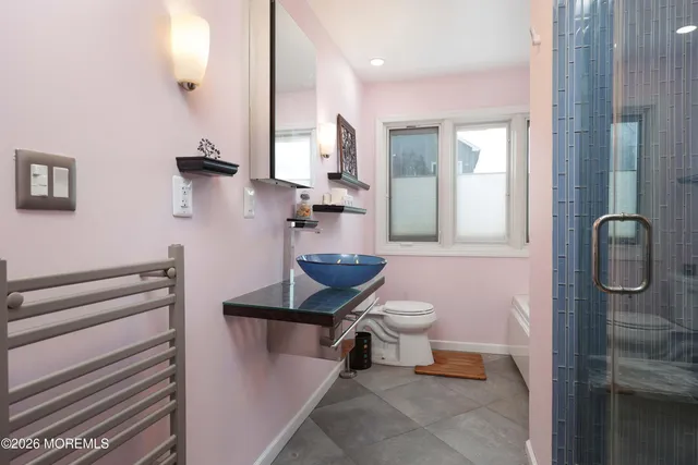 a bathroom with a sink a toilet and shower