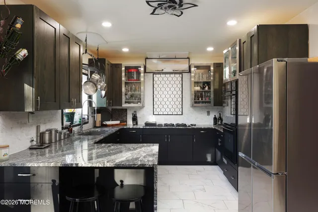 a kitchen with stainless steel appliances granite countertop a sink stove and refrigerator