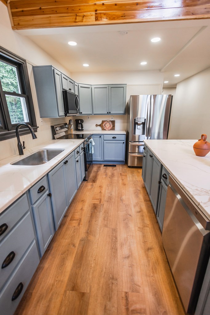 2 Watson Gap Road Mineral Bluff, GA 30559 - Photo 22 of 80 a large kitchen with a large counter top a sink a window and stainless steel appliances