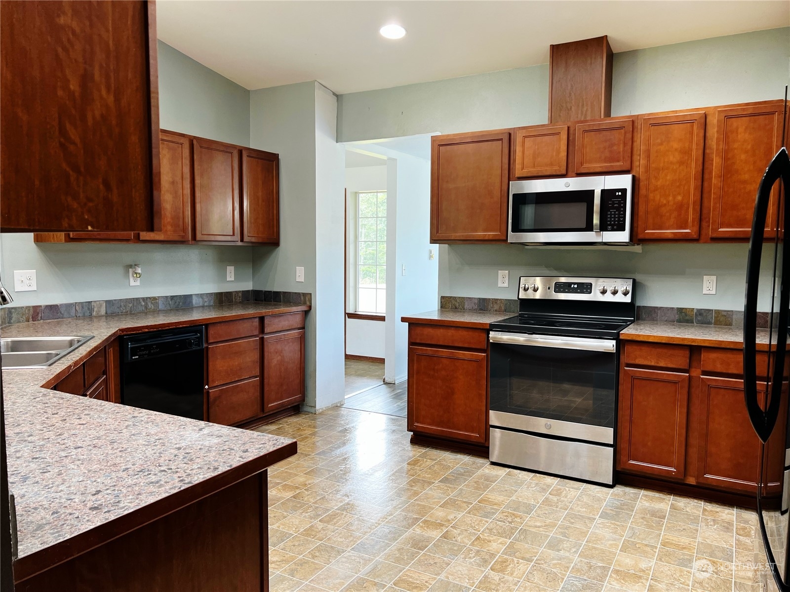742 East Thornton Road Shelton, WA 98584 - Photo 10 of 39 a kitchen with stainless steel appliances granite countertop a stove top oven a sink dishwasher and a microwave oven with wooden cabinets