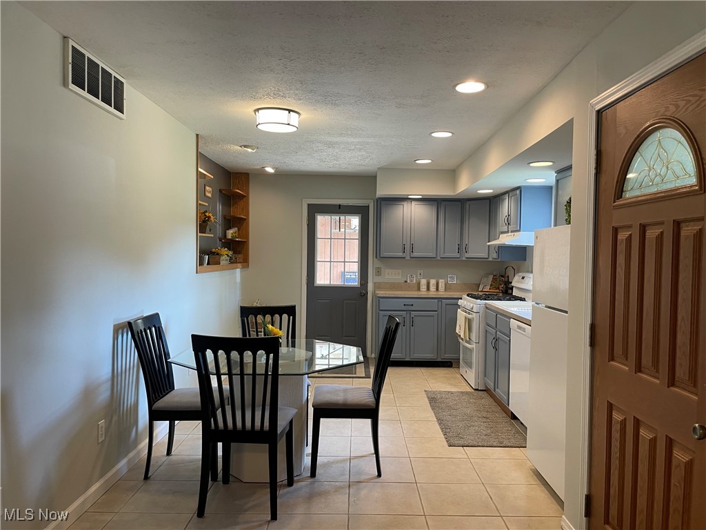 5741 Jaycox Road North Ridgeville, OH 44039 - Photo 6 of 23 Kitchen with gray cabinetry, white appliances, light tile patterned flooring, light countertops, and a textured ceiling