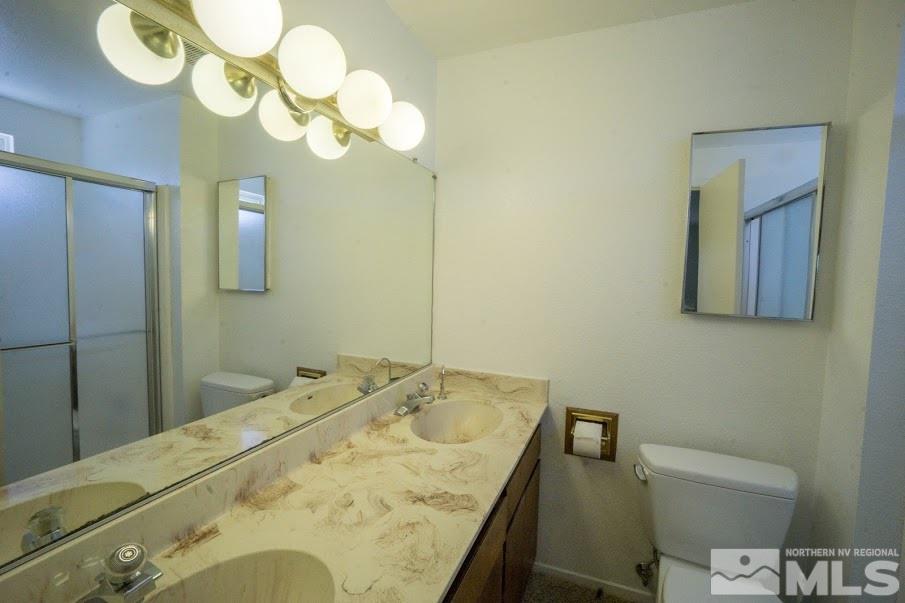 14045 Chamy Drive Reno, NV 89521 - Photo 14 of 25 a bathroom with a granite countertop sink a toilet and mirror