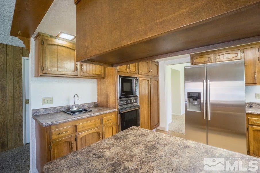 14045 Chamy Drive Reno, NV 89521 - Photo 7 of 25 a kitchen with stainless steel appliances granite countertop a refrigerator a stove and a sink