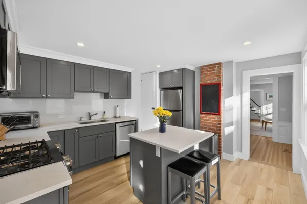 a kitchen with a sink a stove cabinets and wooden floor