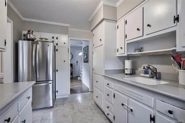 a kitchen with granite countertop a refrigerator and cabinets
